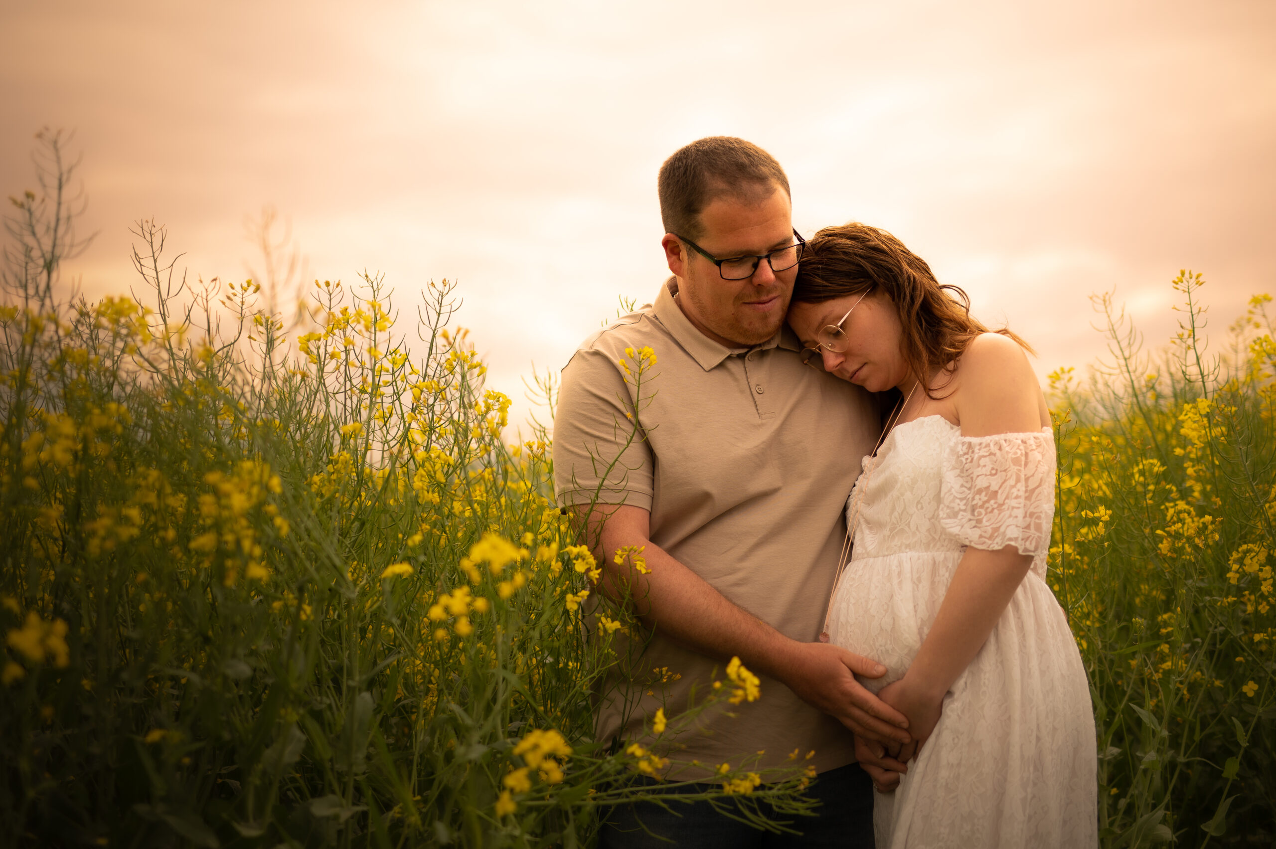 belle photo grossesse couple complcité extérieur photographe femme robe de grossesse couleurs chaude fleurs jaunes champ fleuris tendresse futur bébé