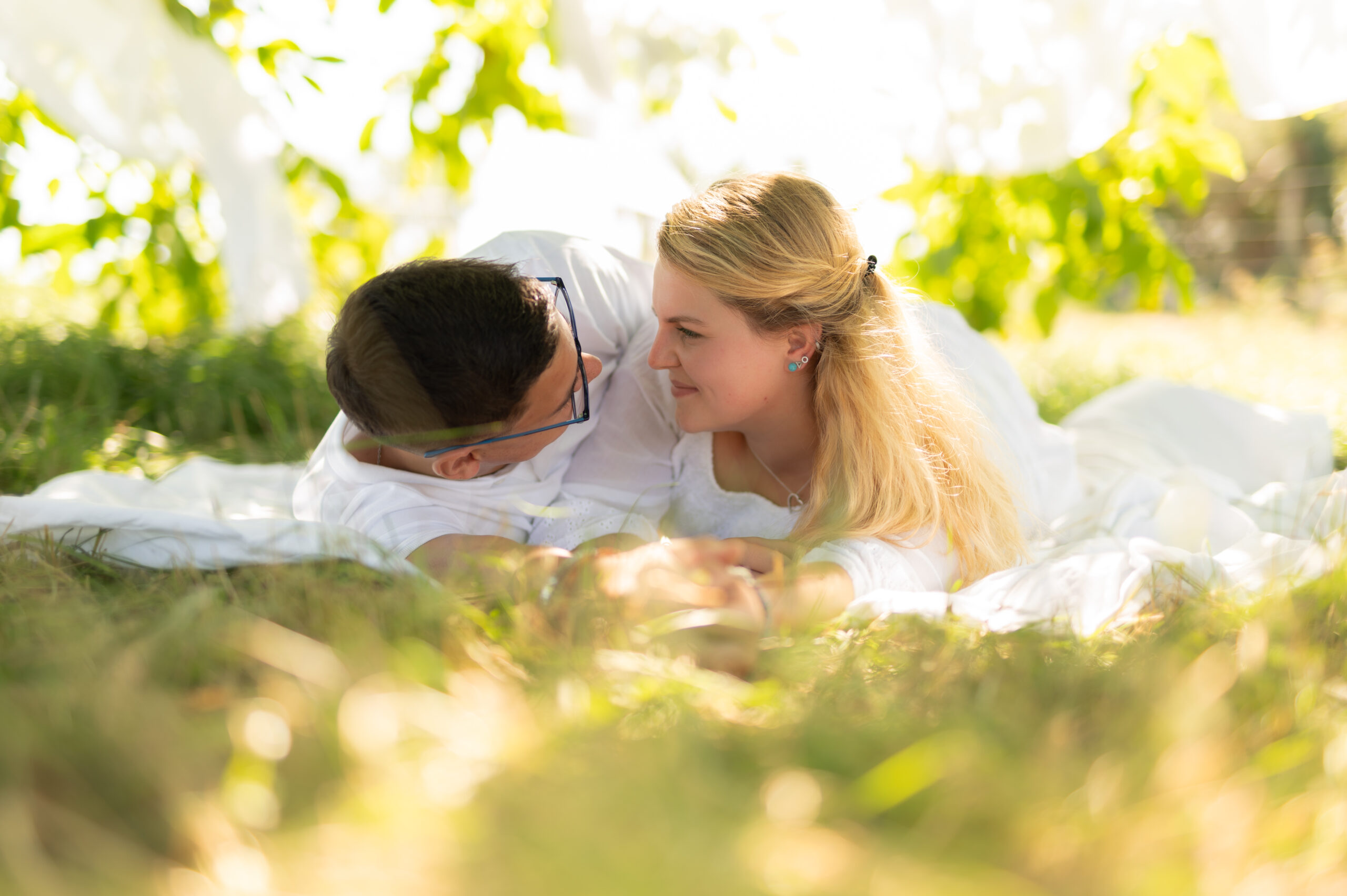 photographe professionnelle couple amour complicité tendresse extérieur arbre foret blanc voilage couleur naturelle regard amoureux