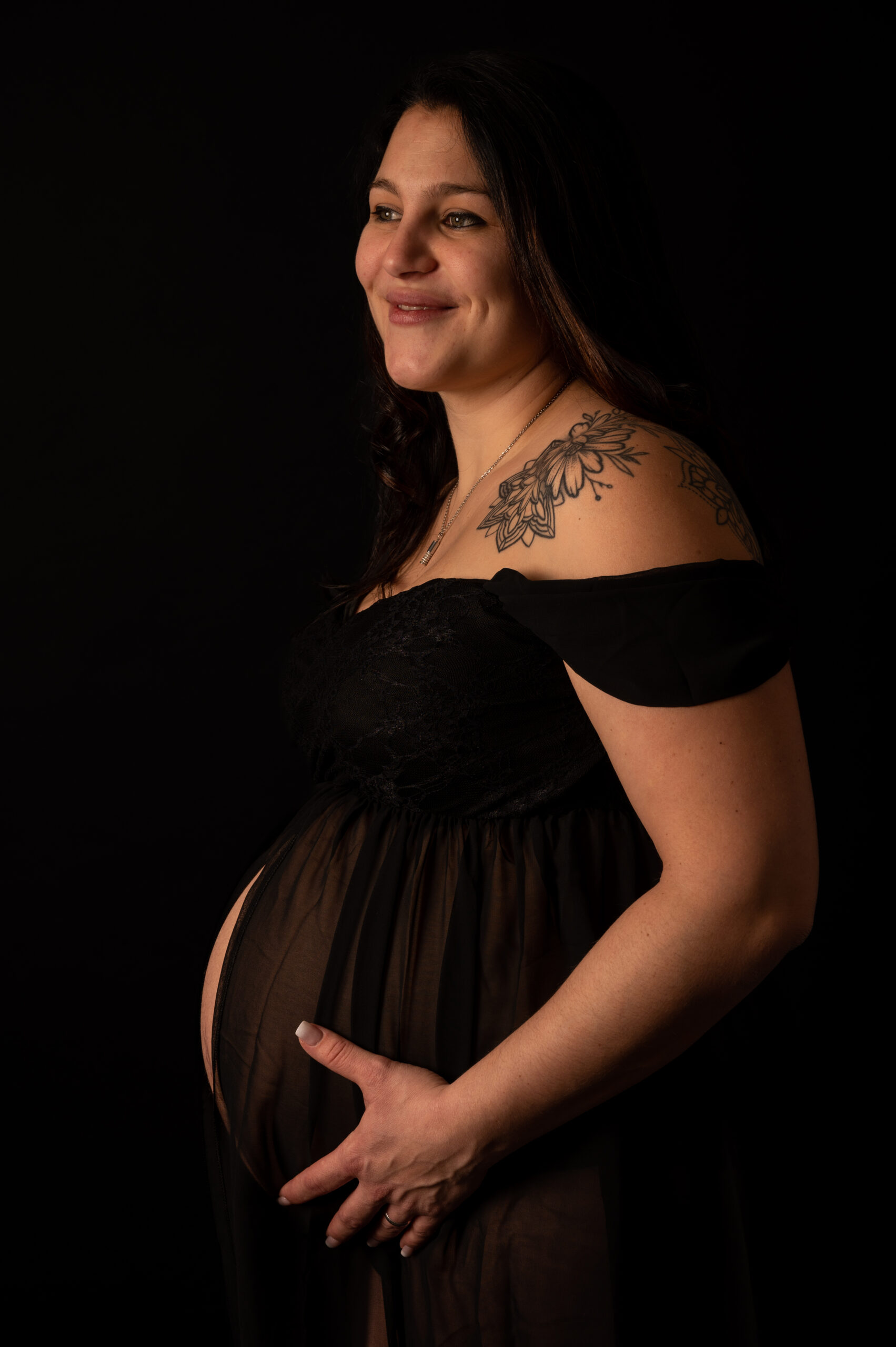 photo grossesse solo studio fond noir belle photographe femme robe de grossesse tatouage sourire naturelle