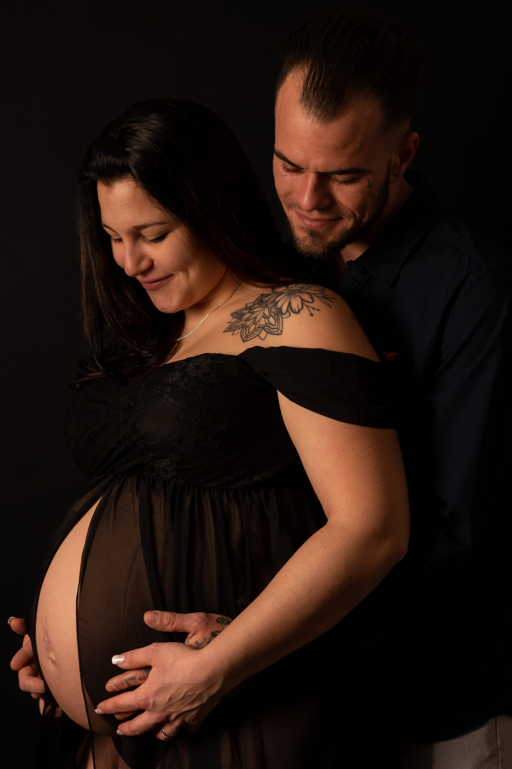belle photo grossesse couple complcité studio fond noir photographe femme robe de grossesse